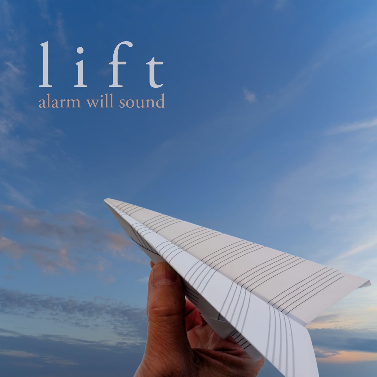 Album cover for Lift by Alarm Will Sound: a hand launches a paper airplane folded from staff paper into a blue sky streaked with clouds.
